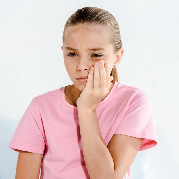 Child Tooth Sensitivity in Cold Weather – Emergency Dentist Garner Child with tooth pain during cold weather, showing signs of tooth sensitivity, needing pediatric dental care in Garner.