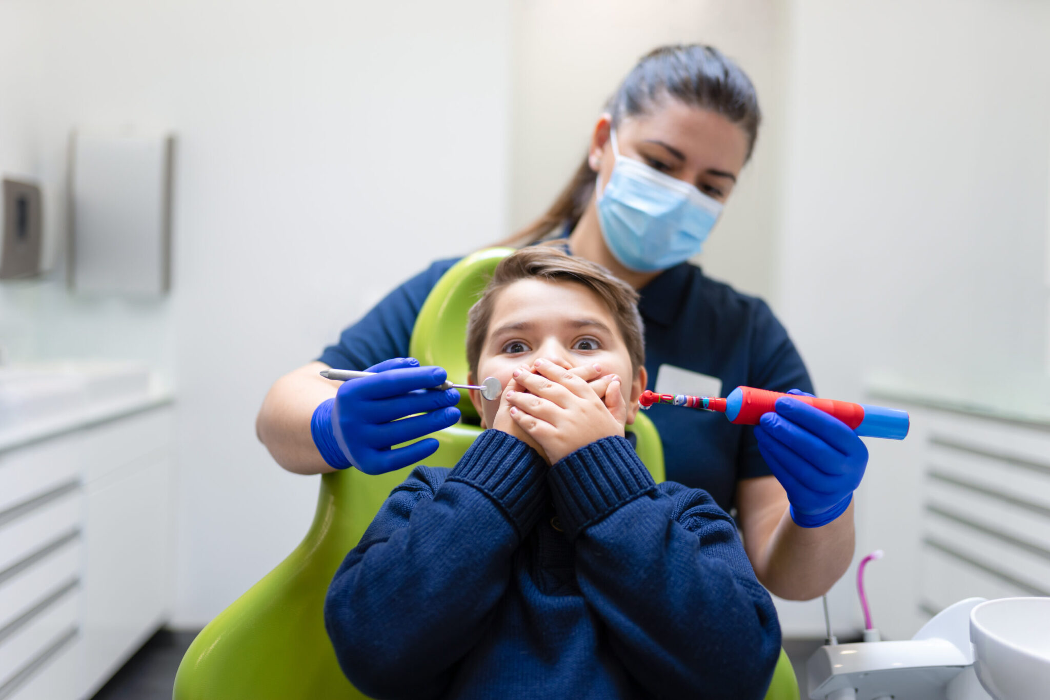 Long Island Pediatric Dentistry in Lawrence, NY, with a child in the dental chair and a hygienist holding kid-friendly tools