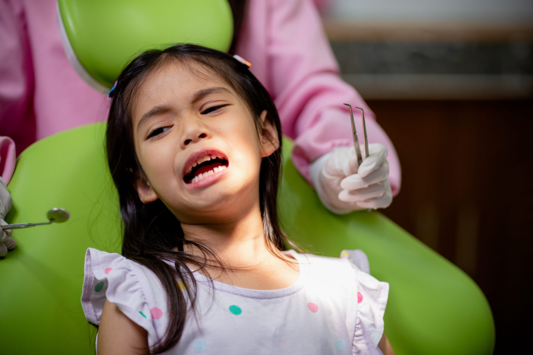 Young girl in a dental chair looking anxious during a pediatric dental exam at Long Island Pediatric Dentistry in Lawrence, NY
