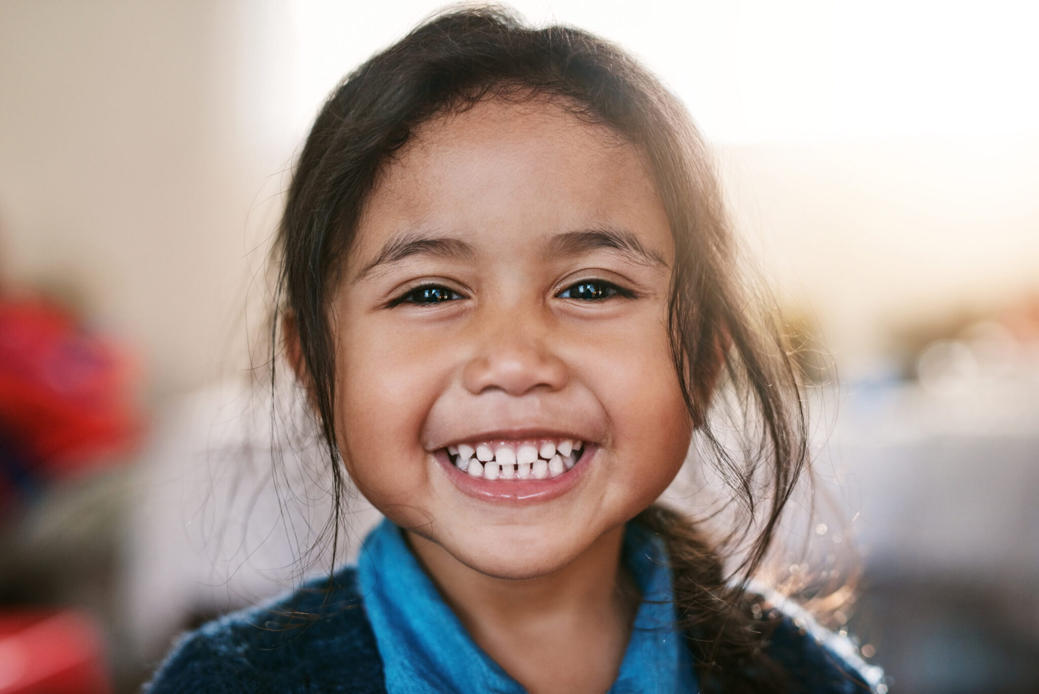 Smiling young girl showing healthy teeth, representing Long Island Pediatric Dentistry in Lawrence, NY