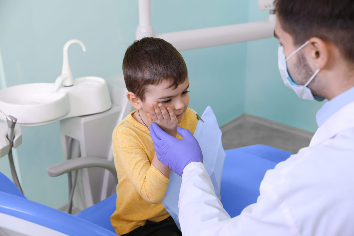 Professional dentist working with little patient in modern clinic Pediatric Dental Emergency Near Me evaluation for a child with a dental injury in Lawrence, NY